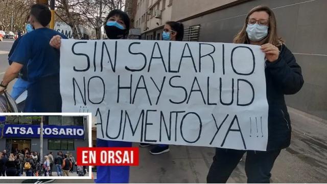Trabajadores de sanatorios privados de Rosario con pancartas, en paro por reclamos salariales frente a una clínica